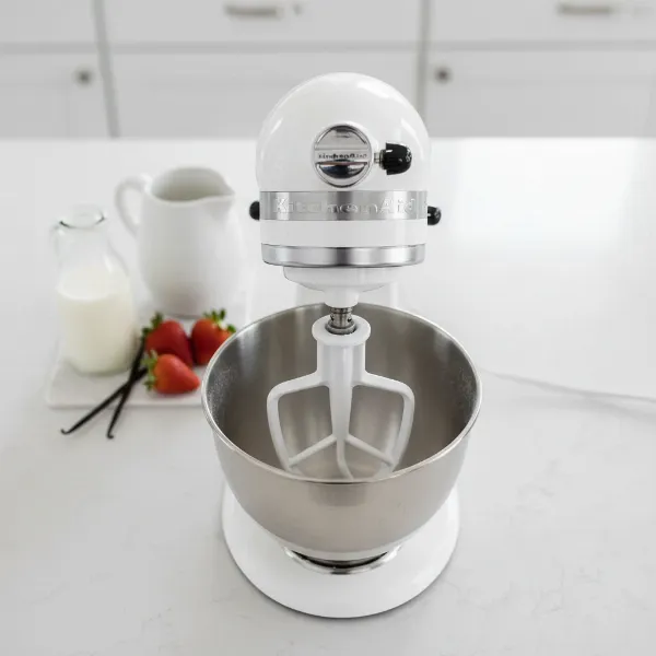KitchenAid stand mixer with white ice cream maker attachment, bowl, and dasher assembled, ready for use.